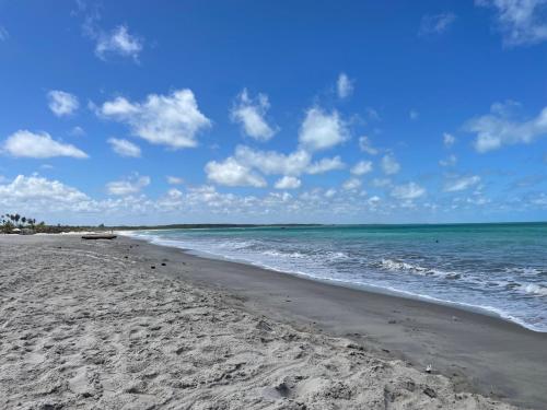a beach with the ocean and a blue sky at Pousada Avalon - Lucena - PB in Lucena