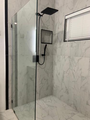 a shower with a glass door in a bathroom at Purevibe Villa Portland Jamaica - Ocean view suite in Port Antonio