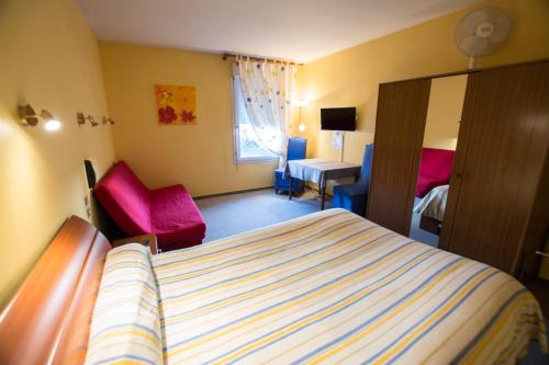ブレシュイールにあるLa Boule d'Orのベッドとデスクが備わるホテルルームです。