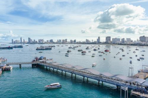 a dock with boats in a harbor with a city at Siam Bayshore Resort Pattaya in Pattaya South