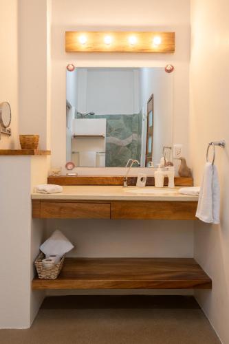 a bathroom with a sink and a large mirror at Casa Mirador 360 in Puerto Escondido