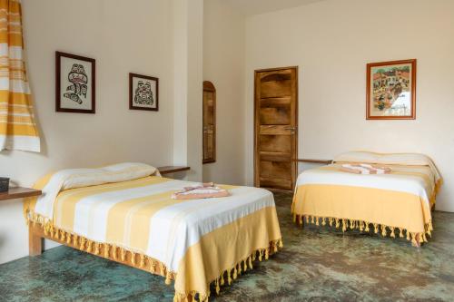 two beds in a room with white walls at Casa Mirador 360 in Puerto Escondido