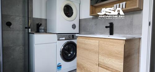 a kitchen with a washing machine and a sink at Casa Della Vita in Jindabyne
