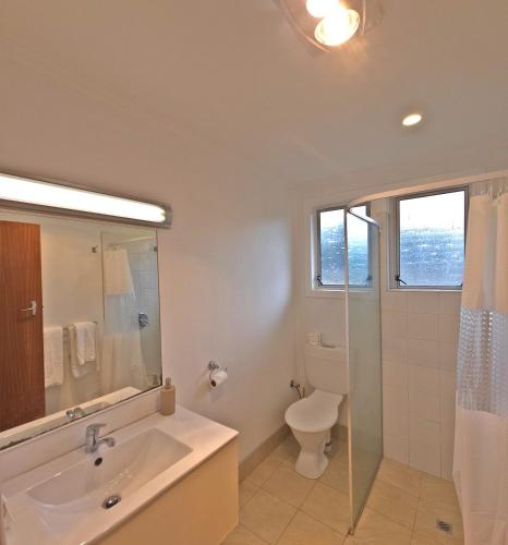 a bathroom with a sink and a toilet at Golden Aura Suites in Stratford