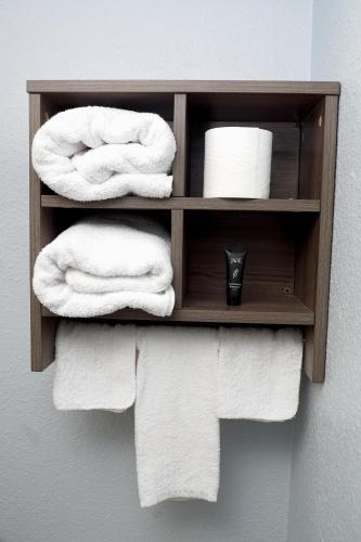 a wooden towel rack with towels on a wall at Legacy Inn - Gallatin in Gallatin