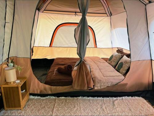 a bedroom with a bed in a tent at Khaosok Malinglamping in Ban Thung Lang Tham