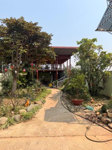 a building with a walkway in front of a garden at Líu homestay in Klong A