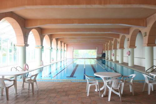 a swimming pool with tables and chairs in a building at Life Leisure Resort in Guanxi