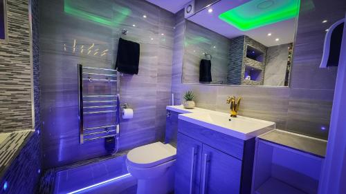 a bathroom with a toilet and a sink and a mirror at Azura Suites in Bradford