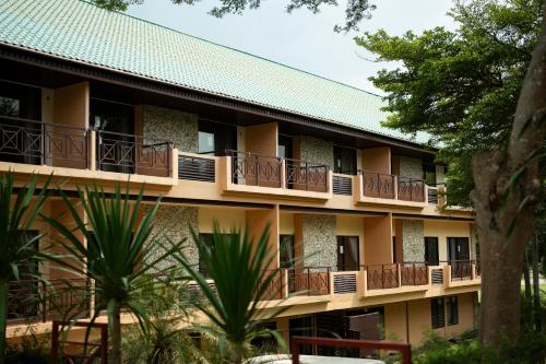 an exterior view of a building with balconies and trees at Rayong Royal Residence in Ban Chang