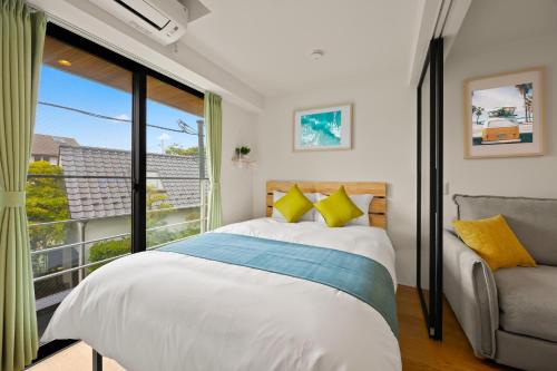 a bedroom with a bed and a large window at 逗子海岸テラス 2階 in Zushi