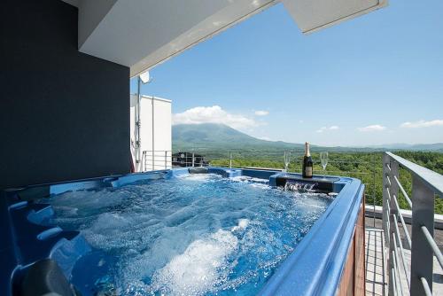 a hot tub on the balcony of a house at Snow Crystal in Kutchan