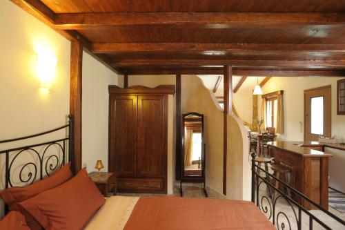 a bedroom with a bed and a kitchen at Apolithomeno Dasos Holiday Villas near Alexandroupolis in Lefkimmi