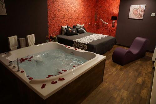 a room with a bath tub with a bed and a bedroom at Motel Los Abedules in Oviedo