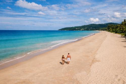 a man and a woman walking on the beach at Kata Hills Condo with Terrace & Sea View O910 in Ka Rorn