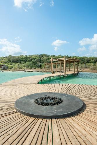 a fire pit on a wooden deck next to the water at Aldea Mayab Luxury Residences by Lagoona in Bacalar