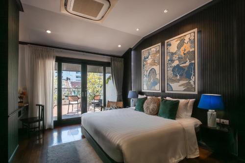 a bedroom with a large bed and a balcony at BAAN 125 STAY Phuket in Phuket