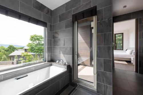 a bathroom with a bath tub and a window at Song Saa Chalet in Niseko