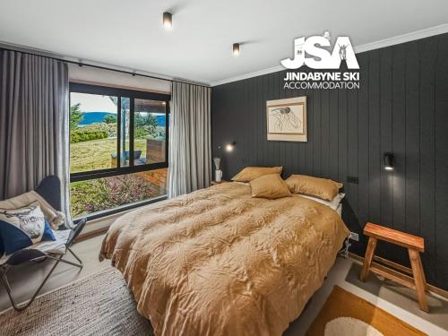 a bedroom with a bed and a chair and a window at The Orchard in Moonbah