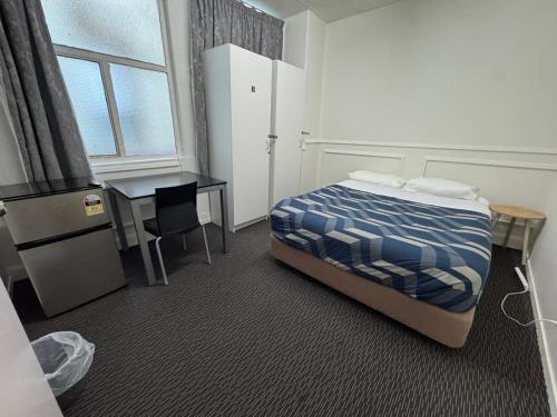 a bedroom with a bed and a table and a desk at BK Hostel in Auckland