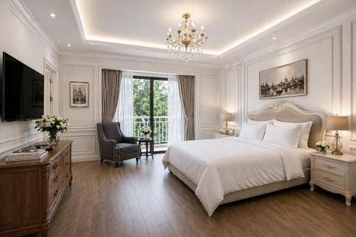 a bedroom with a bed and a chair and a chandelier at Evermist Resort DaLat in Da Lat