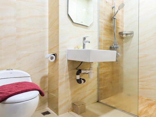 a bathroom with a toilet and a sink at Lovina Spacious Double Studio at Formosa Nagoya in Jodoh