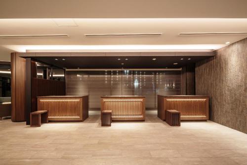 a lobby of a hotel with a row of benches at HOTEL MYSTAYS Fuji Onsen Resort in Fujiyoshida