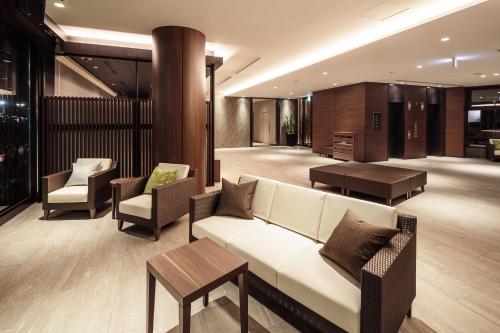 a lobby with a couch and chairs and a table at HOTEL MYSTAYS Fuji Onsen Resort in Fujiyoshida