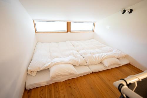 a bed in a small room with a window at いなぎの木箱 in Zentsuji