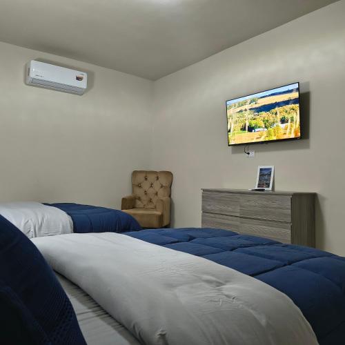 ein Schlafzimmer mit zwei Betten und einem Fernseher an der Wand in der Unterkunft Mukí Galá in Creel