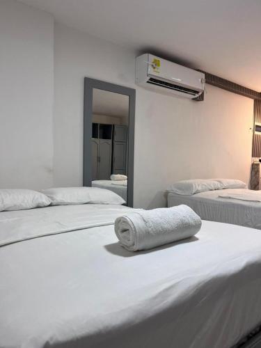 a room with three beds with a mirror and a towel at Apartamento Centro Histórico Cartagena in Cartagena de Indias