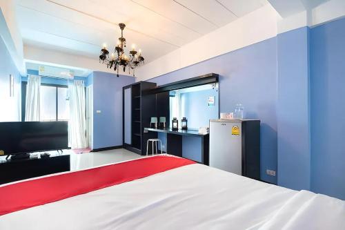 a blue room with a bed and a refrigerator at Chill Guest in Ban Khlong Khwang Klang