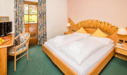 a bedroom with a large bed with a wooden headboard at Hotel Rosental in Luson