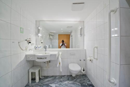 a bathroom with a sink and a toilet and a mirror at Hotel Bären in Rottweil
