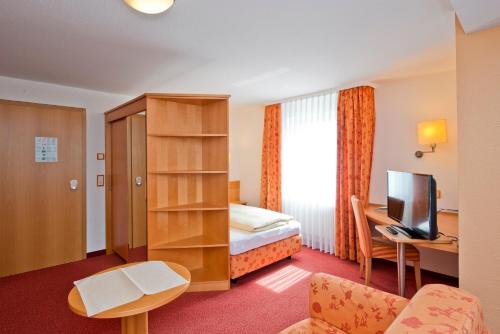 a hotel room with a bed and a television at Hotel Bären in Rottweil