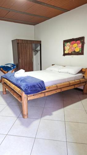 a bed in a room with a wooden frame at HOSTERÍA BRISAS DEL RÍO in Marinilla