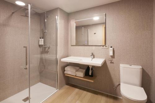 a bathroom with a sink and a shower and a toilet at Hotel Arrosadía Iriguibel in Pamplona