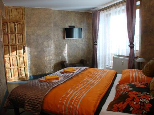 um quarto com uma cama e uma televisão na parede em Apartments Vysoké Tatry em Vysoke Tatry - Horny Smokovec