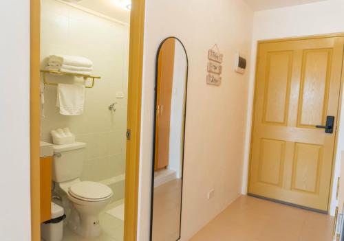 a bathroom with a toilet and a shower with a surfboard at Bayview Haven Studio at Marina Spatial Condominium in Piapi