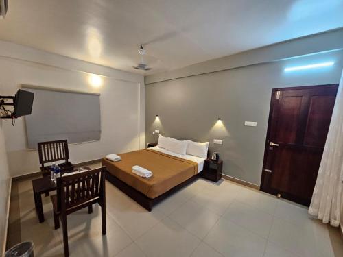 a bedroom with a bed and a flat screen tv at Sea View Balcony room - Tide End Beach Villa in Pallipuram
