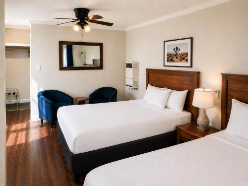 a hotel room with two beds and a ceiling fan at El Dorado Motel in Twain Harte