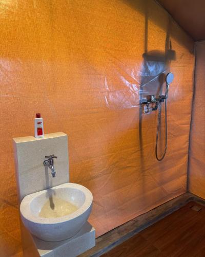 a bathroom with a toilet and a shower at Tikumbar Glamping Pelaga in Plaga
