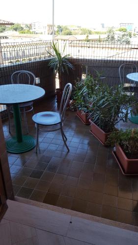 a patio with tables and chairs and potted plants at Nancy House in Florence