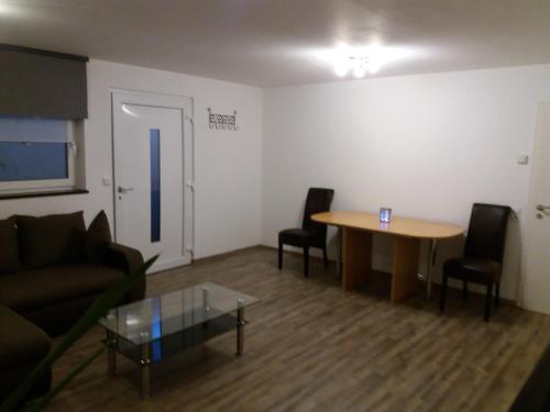 ein Wohnzimmer mit einem Sofa, einem Tisch und Stühlen in der Unterkunft Apartment Rust UG in Rust