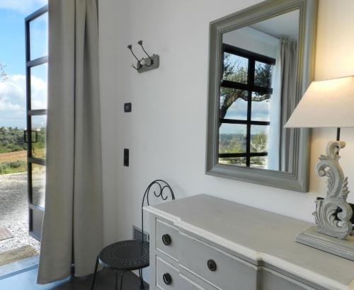 um quarto com um espelho, uma cómoda e uma cadeira em Villalfonsina Country House em Villalfonsina