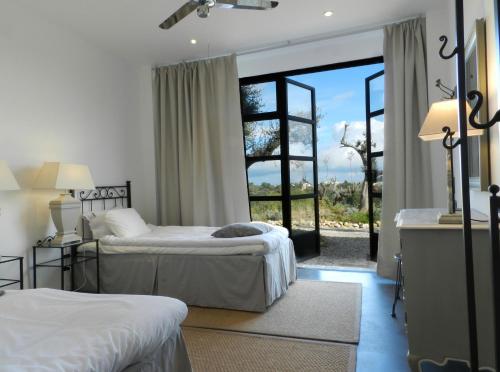 1 dormitorio con 2 camas y ventana grande en Villalfonsina Country House, en Villalfonsina