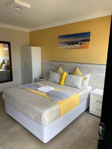 a bedroom with a large bed with yellow walls at Chirute guest lodge in Randfontein