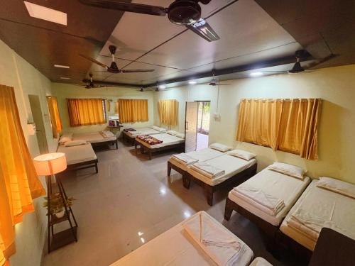 a room with a bunch of beds in it at Matoshree Green Garden Resort in Badlapur