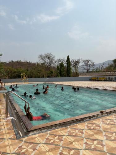a group of people swimming in a swimming pool at Matoshree Green Garden Resort in Badlapur