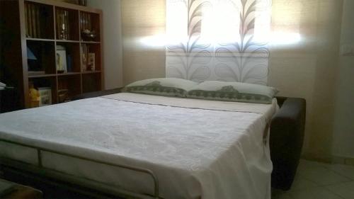 a bedroom with a bed with white sheets and pillows at A casa con Stefania in Settecamini